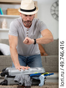 stressed man packing suitcase in a hurry. Стоковое фото, агентство Ingram Publishing / Фотобанк Лори