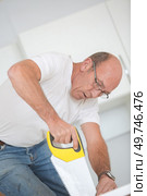 Carpenter using a hand saw. Стоковое фото, агентство Ingram Publishing / Фотобанк Лори