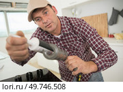 worker holding silicone sealant. Стоковое фото, агентство Ingram Publishing / Фотобанк Лори
