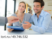 Estate agent handing keys to happy couple. Стоковое фото, агентство Ingram Publishing / Фотобанк Лори