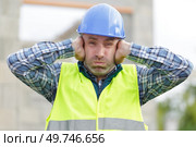 construction suffering from noise pollution on building site. Стоковое фото, агентство Ingram Publishing / Фотобанк Лори