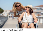 invalid girl on the wheelchair with friend outdoors. Стоковое фото, агентство Ingram Publishing / Фотобанк Лори