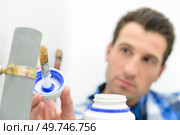 a plumber is gluing pipe. Стоковое фото, агентство Ingram Publishing / Фотобанк Лори