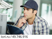 a man is repairing a printer. Стоковое фото, агентство Ingram Publishing / Фотобанк Лори