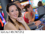 beautiful woman in red dress playing slot machine. Стоковое фото, агентство Ingram Publishing / Фотобанк Лори