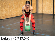 Strong mature woman working out using kettlebell in a gym. Woman working out using kettlebell in a gym. Стоковое фото, агентство Ingram Publishing / Фотобанк Лори