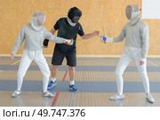 a couple fencing practice with referee. Стоковое фото, агентство Ingram Publishing / Фотобанк Лори