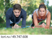 young couple strengthening their muscles in a park. Стоковое фото, агентство Ingram Publishing / Фотобанк Лори