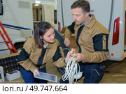 portrait of couple installing cables in campervan. Стоковое фото, агентство Ingram Publishing / Фотобанк Лори
