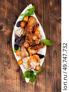 Pieces baked roasted chicken with herbs, top view, flat lay.. Roasting chicken marinated meat. Стоковое фото, агентство Ingram Publishing / Фотобанк Лори