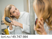beautiful girl combing hair and smiling. Стоковое фото, агентство Ingram Publishing / Фотобанк Лори