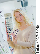 a woman is choosing glasses. Стоковое фото, агентство Ingram Publishing / Фотобанк Лори