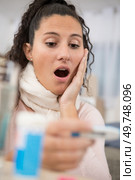 woman looking in shock at the thermometer. Стоковое фото, агентство Ingram Publishing / Фотобанк Лори