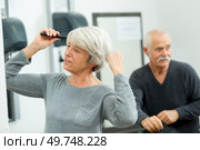 senior woman combing her blond hair with a comb. Стоковое фото, агентство Ingram Publishing / Фотобанк Лори