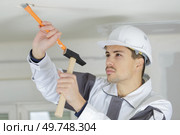 electrician making a hole on the ceiling. Стоковое фото, агентство Ingram Publishing / Фотобанк Лори
