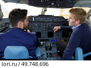 two pilots dressed in uniform flying jet airliner. Стоковое фото, агентство Ingram Publishing / Фотобанк Лори