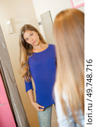 Lady trying on jumper, seeking friend's opinion. Стоковое фото, агентство Ingram Publishing / Фотобанк Лори