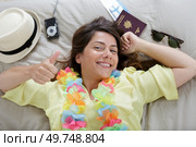 happy woman layed on bed surrounded by travel essentials. Стоковое фото, агентство Ingram Publishing / Фотобанк Лори