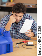 confused worker attempting to assemble ventilation unit. Стоковое фото, агентство Ingram Publishing / Фотобанк Лори