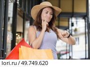 woman out shopping ruefully looking at her wristwatch. Стоковое фото, агентство Ingram Publishing / Фотобанк Лори