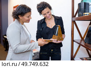 two women looking at metronome. Стоковое фото, агентство Ingram Publishing / Фотобанк Лори