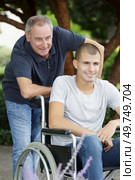 father with wheelchair bound teenage son at the park. Стоковое фото, агентство Ingram Publishing / Фотобанк Лори