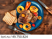 Tasty grilled meat,roasted with pineapple. Grilled steak and ananas on wooden table.. Grilled meat steak with ananas. Стоковое фото, агентство Ingram Publishing / Фотобанк Лори