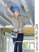 woman in builder hardhat looking at ceiling. Стоковое фото, агентство Ingram Publishing / Фотобанк Лори