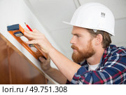 confident builder measuring drywall. Стоковое фото, агентство Ingram Publishing / Фотобанк Лори