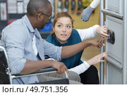 male in wheelchair learns how to open safe. Стоковое фото, агентство Ingram Publishing / Фотобанк Лори