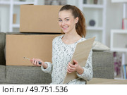 young woman next to a cardbox with new furniture. Стоковое фото, агентство Ingram Publishing / Фотобанк Лори