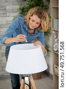 woman changing light bulb in lamp indoors. Стоковое фото, агентство Ingram Publishing / Фотобанк Лори