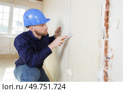 male plasterer in uniform polishing the wall. Стоковое фото, агентство Ingram Publishing / Фотобанк Лори