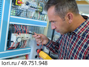 electrician near the low-voltage cabinet. Стоковое фото, агентство Ingram Publishing / Фотобанк Лори
