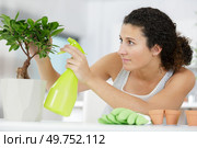 a woman is watering a bonsai. Стоковое фото, агентство Ingram Publishing / Фотобанк Лори