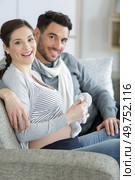 happy pregnant couple on the sofa. Стоковое фото, агентство Ingram Publishing / Фотобанк Лори