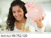 joyous young woman 20s in casual clothing holding piggybank. Стоковое фото, агентство Ingram Publishing / Фотобанк Лори