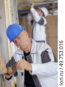 senior electrician concentrating on wiring. Стоковое фото, агентство Ingram Publishing / Фотобанк Лори