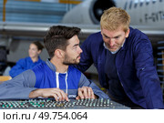 two flight engineers working in hangar. Стоковое фото, агентство Ingram Publishing / Фотобанк Лори