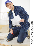 reading manual while installing laminate flooring. Стоковое фото, агентство Ingram Publishing / Фотобанк Лори