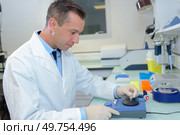 Laboratory technician setting up equipment. Стоковое фото, агентство Ingram Publishing / Фотобанк Лори