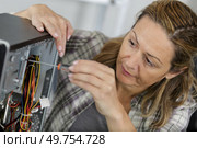 female  unscrewing a back of a laptop. Стоковое фото, агентство Ingram Publishing / Фотобанк Лори