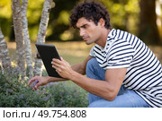 handsome man holding a tablet looking for plant references. Стоковое фото, агентство Ingram Publishing / Фотобанк Лори