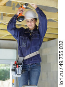 woman using drill on ladder. Стоковое фото, агентство Ingram Publishing / Фотобанк Лори