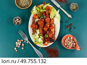 Braised pork ribs in tomato sauce served on a dark plate. BBQ.. Braised pork spare ribs. Стоковое фото, агентство Ingram Publishing / Фотобанк Лори