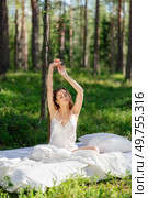 Woman sleeps on a mattress in the summer forest. Girl wakes up in a summer forest. Стоковое фото, агентство Ingram Publishing / Фотобанк Лори