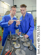 Engineers assessing parts in workshop. Стоковое фото, агентство Ingram Publishing / Фотобанк Лори