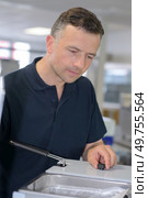man fixing a deep-fryer. Стоковое фото, агентство Ingram Publishing / Фотобанк Лори