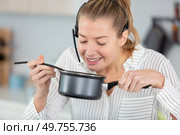 woman wearing handsfree headset spelling food in saucepan. Стоковое фото, агентство Ingram Publishing / Фотобанк Лори