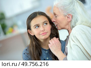 Little girl and grandma whispering secrets. Стоковое фото, агентство Ingram Publishing / Фотобанк Лори